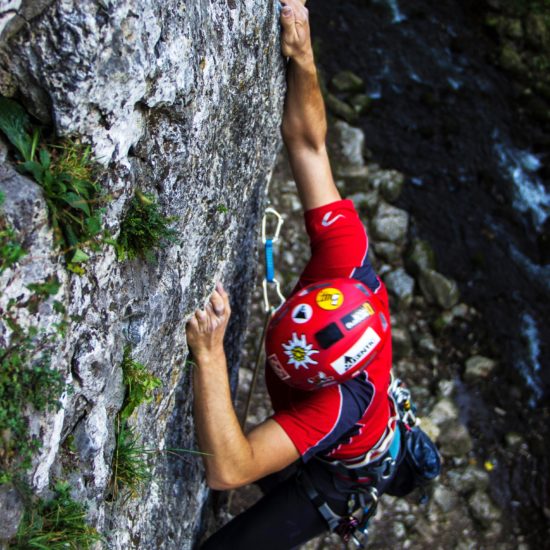 climber in red helmet holding on to a finger pocket